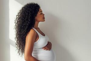 gravid svart kvinna i en vit tank topp i profil foto