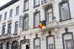 belgisk och europeisk flaggor på de balkong av de historisk station hotell byggnad i aalst belgien på solig sommar dag foto