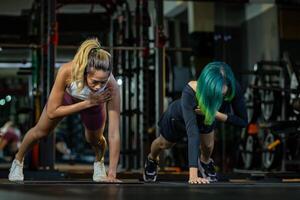 två asiatisk kvinnor Gym partner håller på med bordläggning med de axel kran övning på de golv som stärka de magmuskler abdominal och kärna kropp muskel foto