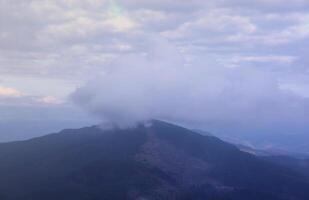 morgon- se från de dragobrat berg toppar i karpater berg, ukraina. molnig och dimmig landskap runt om drahobrat toppar foto