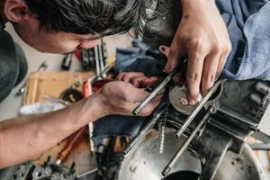 mekaniker är montera en motorcykel kolv i garage.demontering och underhåll av motorcykel motor foto