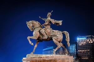 tasjkent, uzbekistan - Mars 14, 2023 monument amir timur eller tamerlane på nattetid mot de bakgrund av de hotell. foto