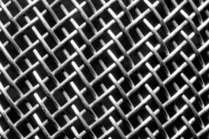 svartvit textur av en skinande metall durkslag eller galler. abstrakt bakgrund. foto