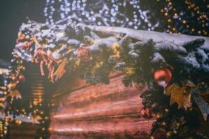 jul eller ny år marknadsföra i en Europa med hus dekorerad med leksak bollar och kransar på natt. årgång filma estetisk. foto