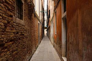 typisk smal gata med historisk hus i Venedig. smal fotgängare gator av Venedig mellan de kanaler. foto