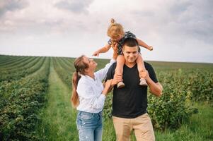 Lycklig familj med liten dotter utgifterna tid tillsammans i solig fält. foto