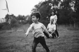 far, mor och son spelar med leksak flygplan i de parkera. vänlig familj. människor har roligt utomhus. bild tillverkad på de bakgrund av de parkera och blå himmel. begrepp av en Lycklig familj foto