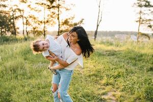 mor och dotter har roligt i de parkera. lycka och harmoni i familj liv. skönhet natur scen med familj utomhus- livsstil foto