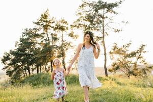 mor och dotter har roligt i de parkera. lycka och harmoni i familj liv. skönhet natur scen med familj utomhus- livsstil foto