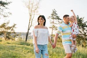 Lycklig familj begrepp - far, mor och barn dotter har roligt och spelar i natur foto