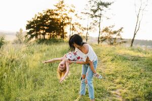 mor och dotter har roligt i de parkera. lycka och harmoni i familj liv. skönhet natur scen med familj utomhus- livsstil foto