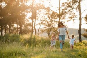 mor och två döttrar har roligt i de parkera. lycka och harmoni i familj liv. skönhet natur scen med familj utomhus- livsstil foto