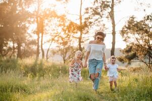 mor och två döttrar har roligt i de parkera. lycka och harmoni i familj liv. skönhet natur scen med familj utomhus- livsstil foto