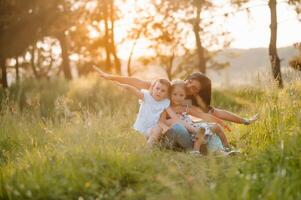 mor och två döttrar har roligt i de parkera. lycka och harmoni i familj liv. skönhet natur scen med familj utomhus- livsstil foto