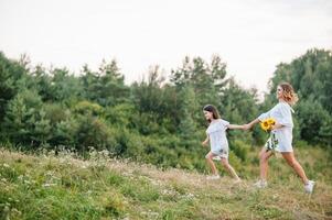 mor och dotter har roligt i de parkera. lycka och harmoni i familj liv. skönhet natur scen med familj utomhus- livsstil. mors dag foto