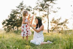 mor och dotter har roligt i de parkera. lycka och harmoni i familj liv. skönhet natur scen med familj utomhus- livsstil foto