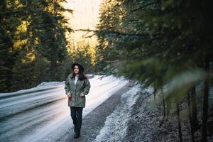 Lycklig flicka med hatt i skog på berg väg bakgrund, koppla av tid på Semester begrepp resa ,Färg av årgång tona och mjuk fokus. foto