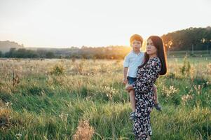 stilig mor och stilig son har roligt på de natur. Lycklig familj begrepp. skönhet natur scen med familj utomhus- livsstil. Lycklig familj vilar tillsammans. lycka i familj liv. mödrar dag foto