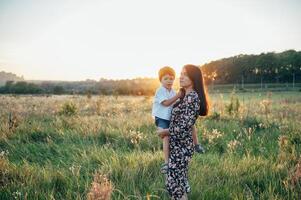 stilig mor och stilig son har roligt på de natur. Lycklig familj begrepp. skönhet natur scen med familj utomhus- livsstil. Lycklig familj vilar tillsammans. lycka i familj liv. mödrar dag foto