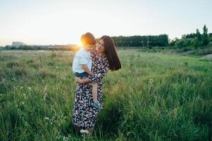 stilig mor och stilig son har roligt på de natur. Lycklig familj begrepp. skönhet natur scen med familj utomhus- livsstil. Lycklig familj vilar tillsammans. lycka i familj liv. mödrar dag foto