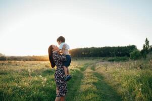 stilig mor och stilig son har roligt på de natur. Lycklig familj begrepp. skönhet natur scen med familj utomhus- livsstil. Lycklig familj vilar tillsammans. lycka i familj liv. mödrar dag foto