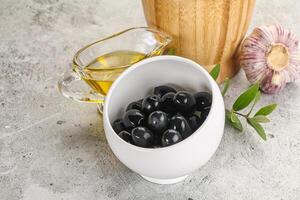 svart oliver med olja och gren foto