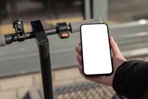 hand använder sig av mobil telefon skärm mockup, smartphone app för hyra sparka skoter foto
