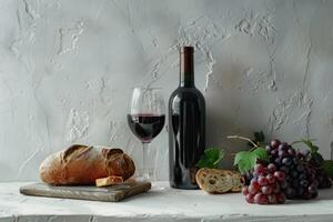vin flaska och vin glas fortfarande liv med vindruvor och bröd på vit plåster bakgrund. vin foto