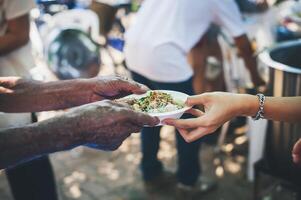 volontärer erbjudande fri mat till de fattig. de begrepp av mat delning. foto
