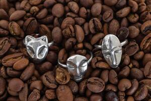 samling av elegant silver- ringar på en bakgrund av kaffe bönor, topp se. hantverk dyrbar Artikel. Smycken Tillbehör. foto