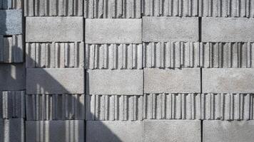 solljus och skugga av byggnad strukturera på stack av betong block yta foto