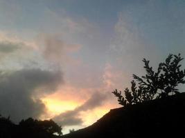 dramatisk solnedgångshimmel med moln. ljus dramatisk himmel och mörk mark. foto