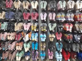 olika typer av skor och sandaler visas i en sko affär skyltfönster. foto