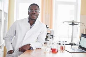 en afroamerikansk arbetare arbetar i ett laboratorium och utför experiment. foto