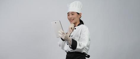 asiatisk kvinna kock håller smartphone eller digital surfplatta och fick beställning från online foto