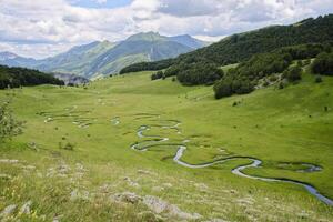 se av de studeni potok slingrande ström belägen nära de by av umoljani, på de sydlig sida av bjelasnica, bosnien och hercegovina. skön landskap och lantlig turism. foto