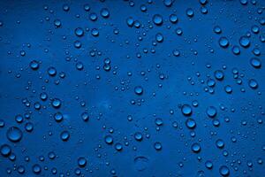 lugn blå, stänga upp av vatten droppar på djup blå yta. foto