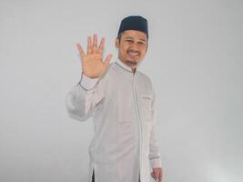 moslem asiatisk man som visar Lycklig uttryck när vinka hand till hälsa någon foto