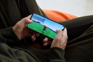 roblox mobil ios spel på iphone 15 smartphone skärm i manlig händer under mobil gameplay foto