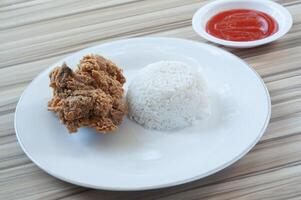 friterad kyckling med vit ris och grönsaker som garnering foto