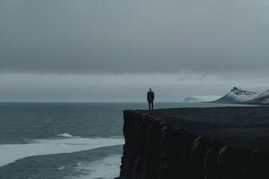 man stående på topp av en berg i island foto