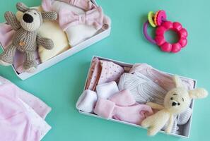 bebis och barn kläder och stickat leksaker i kartong låda. foto