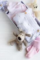 bebis kläder, stickat leksaker, strumpor i låda. foto