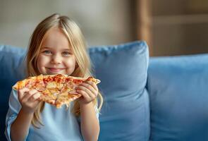 glad blond flicka äter pizza på blå soffa foto