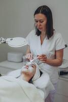 en flicka på en kosmetolog gör kosmetisk förfaranden. hud rensning foto