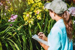 flickan noterar förändringarna, orkidétillväxt i trädgården. vacker orkidébakgrund i naturen