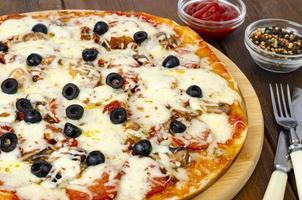 hemlagad pizza med pepperoni, svamp, mozzarella och oliver. studiofoto foto