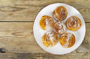 tallrik med hemgjorda kanelbullar på träbord. studiofoto foto