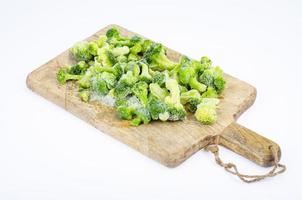 rå frysta bio grönsaker på trä skärbräda. studiofoto. foto