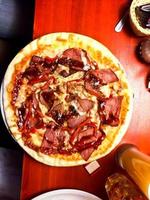 pepperoni pizza med korv, ost, mozzarella, oliver och bas foto